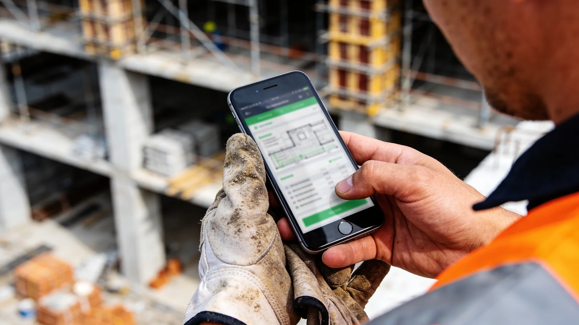 Construction team on job site with project management tool on smartphone